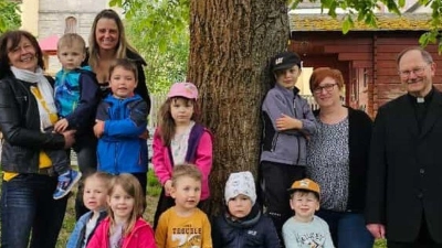 Lisa Schiml (von links) und Stefanie Schrembs (Vorsitzende des Frauenbund Waldeck) an der neuen Bank mit (von rechts) Pfarrer Heribert Stretz und Kindergartenleiterin Kerstin Dilling im Kreise von zahlreichen Kindern. <br> (Bild: Frauenbund Waldeck/exb)