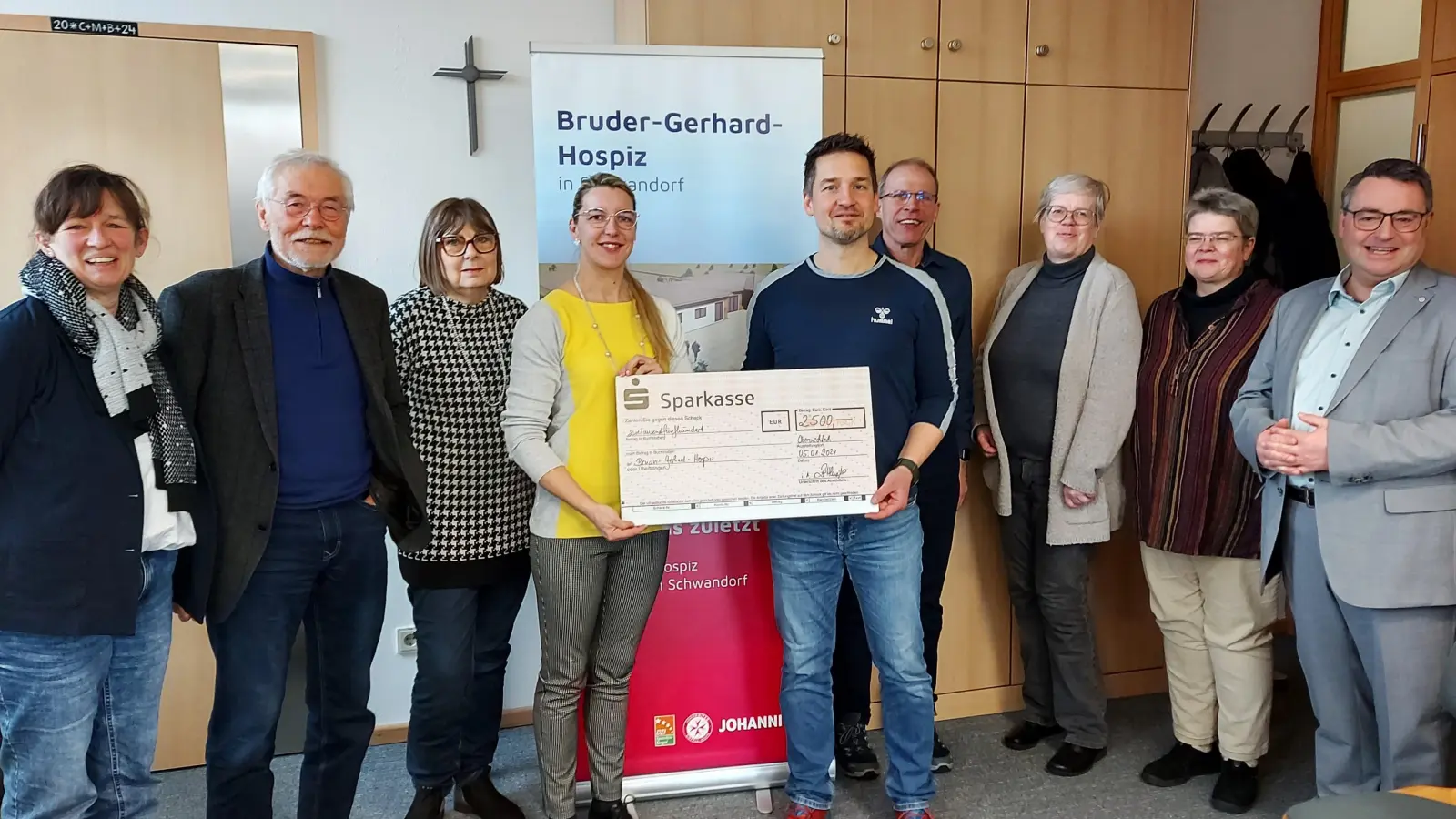 Oberstudienrat Michael Teplitzky übergibt den Erlös des jüngsten Spendenlaufs in Höhe von 2500 Euro mit einem symbolischen Scheck an die Leiterin des Bruder-Gerhard-Hospizes in Schwandorf, Katharina Salbeck. Weitere Lehrkräfte und Vertreter der Hospizbewegung ziehen Bilanz.  (Bild: lg)