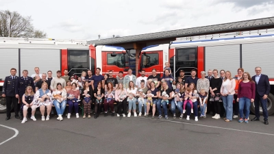 Die jungen Familien mit den Neugeborenen gemeinsam mit den Vertretern der Eltern-Kind-Gruppe, des BRK und der Stadt Waldsassen sowie Bürgermeister Bernd Sommer (rechts) und Feuerwehr-Kommandant Tobias Tippmann (links).  (Bild: Florian Müller/exb)