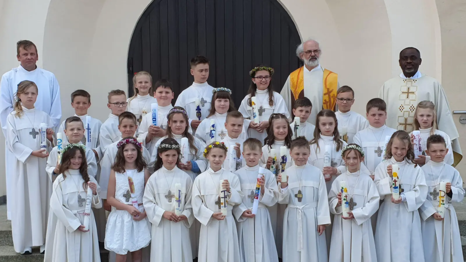 Die 27 Kommunionkinder aus Schwarzenfeld und Umgebung mit Pfarrer Hheinrich Rosner (Hinten Zweiter von rechts), Pfarrvikar Christian Ogu (Hinten rechts) und Gemeindereferent Markus Seefeld (Hinten links). (Bild: Markus Seefeld)