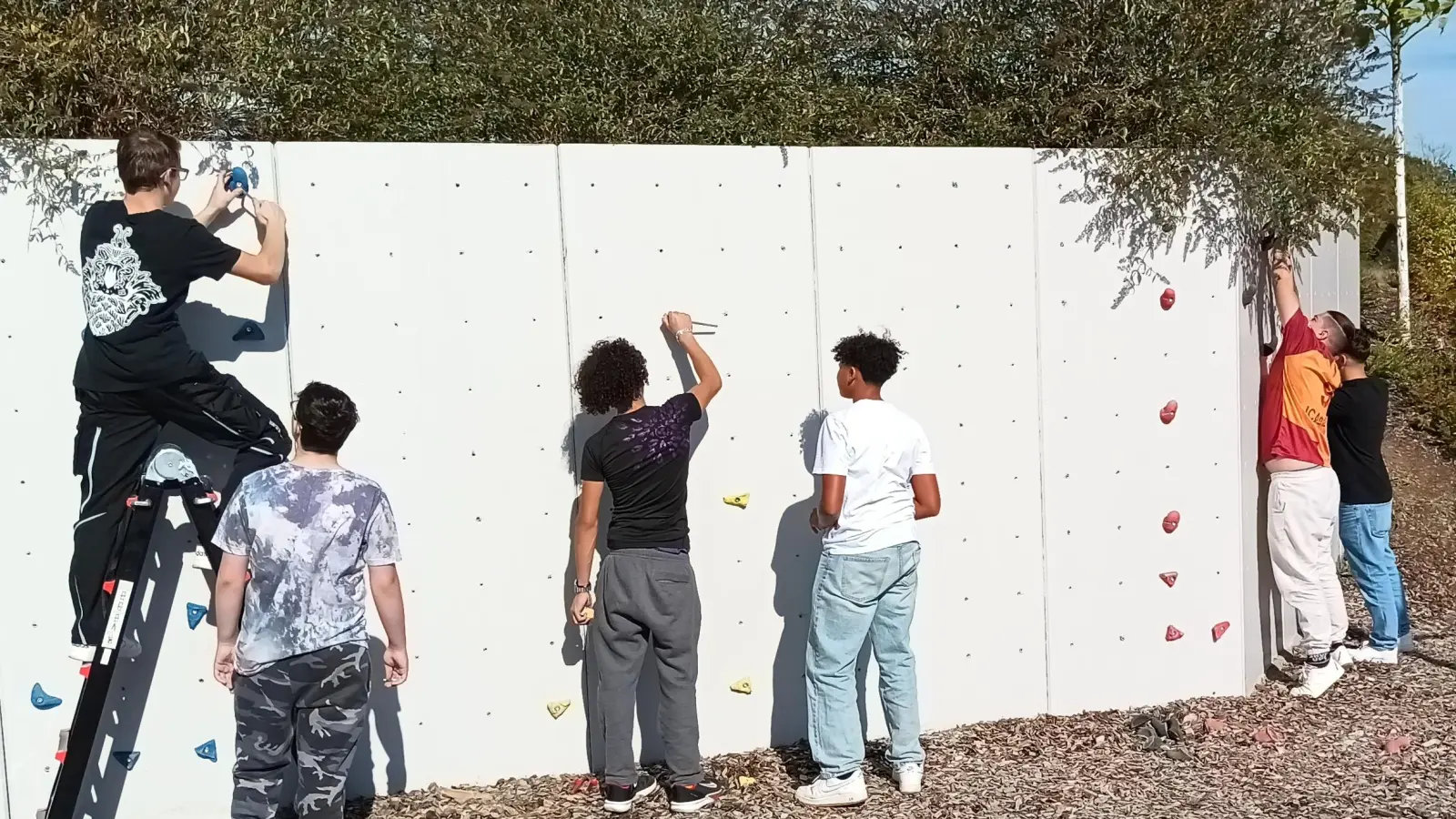 Die Schüler bei der Arbeit an der frisch sanierten Kletterwand.  (Bild: Thomas Ott)