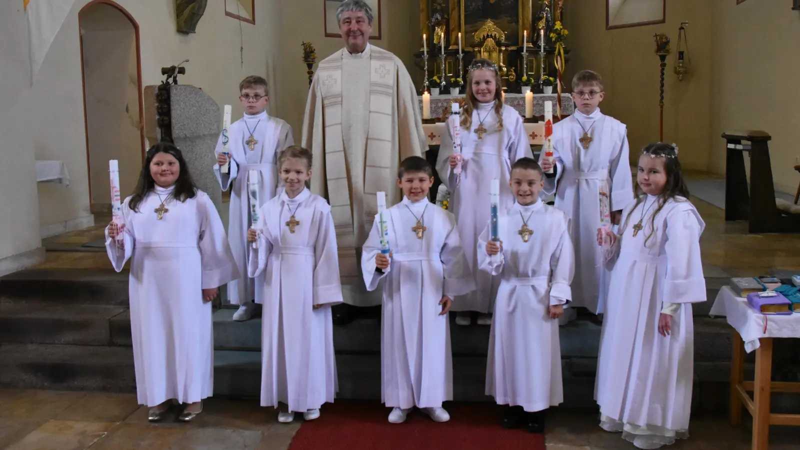 Das sind die Erstkommunionkinder aus Döllnitz mit Pfarrer Adam Nieciecki, der vor dem Fest nach den Sonntagsgottesdiensten im Pfarrheim die Kinder auf die Kommunion vorbereitete.<br> (Bild: Sieglinde Schärtl)