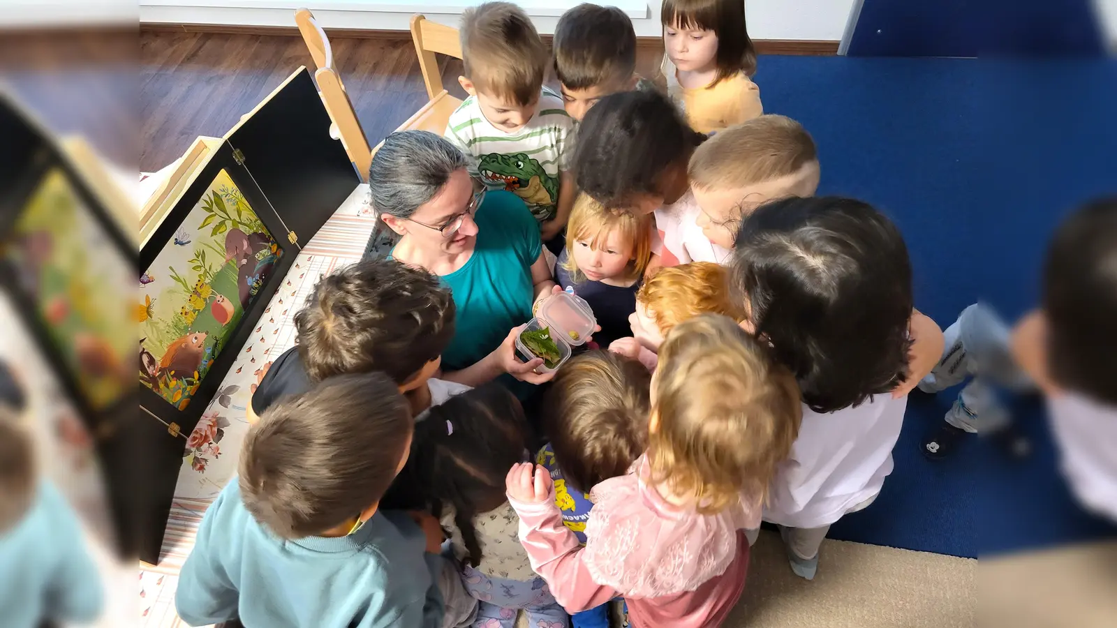 Christina Präßler von der Stadtbibliothek zeigt den Kindern der „Wichtelvilla“ eine Schnecke. (Bild: Susanne Wenisch)