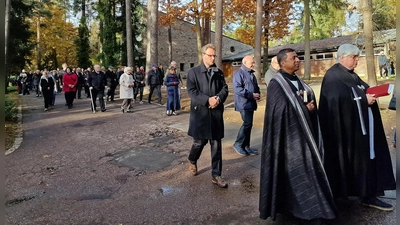 Die Geistlichen ziehen zum Friedhofskreuz, die Gläubigen folgen. (Bild: R. Kreuzer)