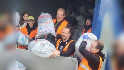 Fleißig verluden die Rotkreuzler die Kleiderspenden von den Sammlungsfahrzeugen auf den Container einer Spedition, bis dieser am Ende der Aktion randvoll war. (Bild: BRK Erbendorf/exb)