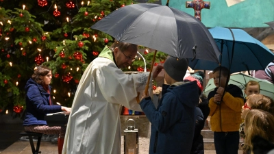 Alle Kinder durften am Ende der Andacht den Regenschirm bei Pfarrer Thomas Stohldreier gegen den Segen eintauschen und so beschirmt von Gott ins neue Jahr gehen. (Bild: kki)