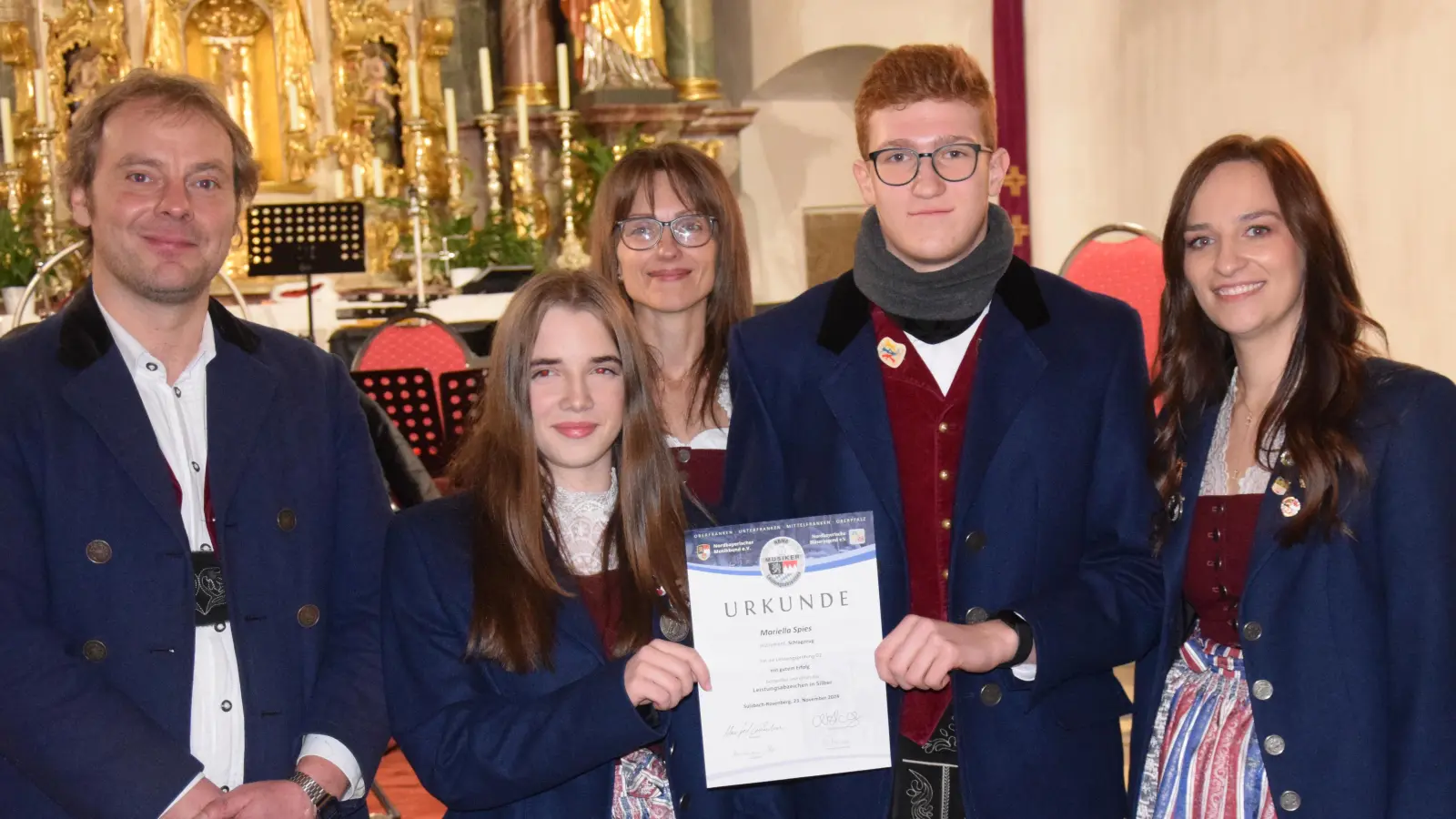 Mariella Spies und Gabriel Junkes haben das Silberne Leistungsabzeichen des Nordbayerischen Musikbundes mit großem Erfolg bestanden. Dazu gratulierten Vorsitzender Benjamin Siegert(li.) sowie die musikalischen Leiterinnen Anja Paulus (hi. Mitte) und Tanja Fruth (re.) (Bild: Paul Böhm )