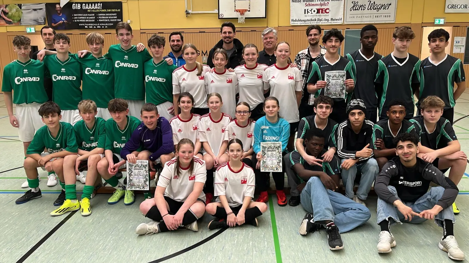 Nach drei Stunden Hallenfußball standen die Sieger der Amberger Schulen fest: Das Gregor-Mendel-Gymnasium (grün) mit Lehrer Michael Muck (hinten 2.v.l.), die Schönwerth-Realschule (weiß) mit Lehrer Stefan Meisel (hinten 3.v.l.) und für die Mittelschule, die Dreifaltigkeits-Mittelschule (schwarz) mit Lehrer Philipp Keilholz (hinten 5.v.l.); mit dabei der Hallen-”Chef” Matthias Harbauer (hinten 1.v.l.) und „Hausherr”. <br>und Schulleiter Christian Zenger (hinten 4.v.l.). (Bild: Thomas Gebele)