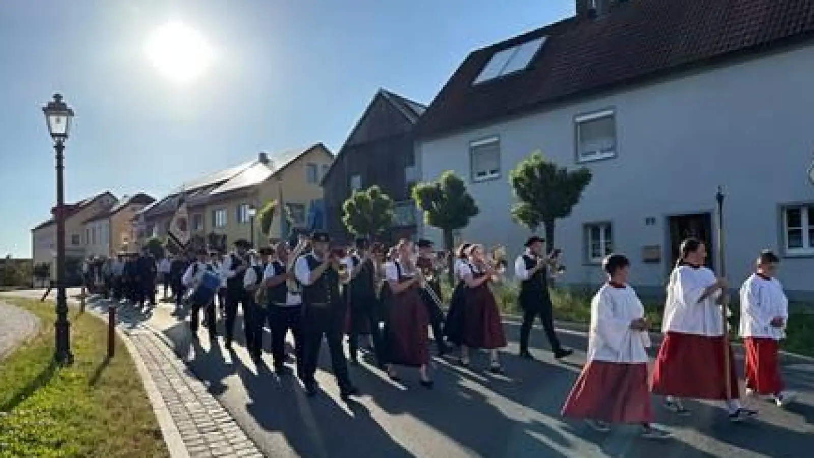 Bei strahlendem Sonnenschein bewegt sich der Festzug zur Kirche Sankt Johannes der Täufer. (Bild: Heiner Reber)