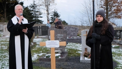 Am neu errichteten Holzkreuz im Friedhof in Floß segnete Pfarrer Wilfried Römischer die Gräber und die Gläubigen, die ihren verstorbenen Angehörigen gedachten. (Bild: Fred Lehner)