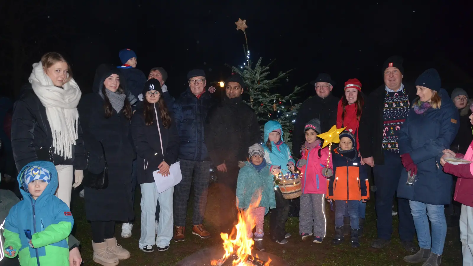 Vor dem Lagerfeuer und dem geschmückten Christbaum feiert die Siedlergemeinschaft Advent.  (Bild: Helmut Kunz)