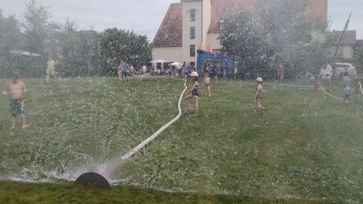 Mehr braucht es nicht, um maximalen Spaß für die Kinder zu bieten: hochsommerliche Temperaturen und eine Wasserwand, die Hüpfburg im Hintergrund tut ein Übriges.  (Bild: Ulrich Reindl)