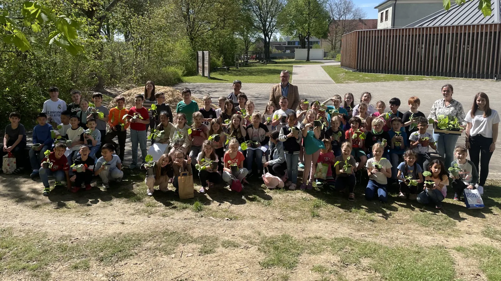 Die Drittklässler der Grundschule Waldsassen mit den drei Klassenleiterinnen sowie Silvia Engel und Klaus Schuster (hinten, Mitte) vom OGV Waldsassen nach der Ausgabe der vorgezogenen Kürbispflanzen. (Bild: Klaus Schuster/exb)