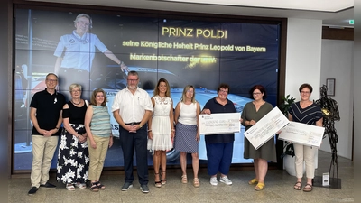 Im Bild von links: Bürgermeister Bernd Sommer, Gudrun Sirtl/KAB, Gabi Treml-Laubert/2. Vorsitzende OGV Waldsassen, Klaus Schuster/Organisator, Sandra Winter/Vertreterin des Hauptsponsors, Doris Wagner-Zeeh, Karin Borchers, Barbara Schmid, Sonja Schnurrer; im Hintergrund an der TV-Wand der Ehrengast der Veranstaltung: seine Königliche Hoheit Prinz Leopold von Bayern mit seinem BMW M1.<br> (Bild: Klaus Schuster)