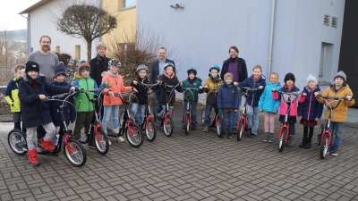 Rektorin Friederike Bösl (dritte von rechts) und Konrektor Peter Grosser (rechts) freuen sich mit den Kindern der zweiten Klasse über die Tretroller, die von den Vorsitzenden des Elternbeirats, Alexander Ried (links) und Florian Schwindler, an die Grundschule gebracht wurden. (Bild: Elfried Weiß)