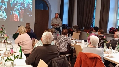 Franz Völkl (Mitte) zeigt beim Seniorennachmittag der Pfarrei Bilder vom Kirchbau und Kirchweih der Pfarrkirche St. Sebastian Waldturn. (Bild: Elisabeth Lukas)