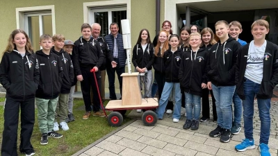 Im Beisein der Ministranten dankt Pfarrer Erwin Bauer (Sechster von links) dem leidenschaftlichen Schreiner Karl Schaller (rechts daneben) für sein Meisterstück: den Bollerwagen für den Lautsprecher. (Bild: Karl Ziegler)