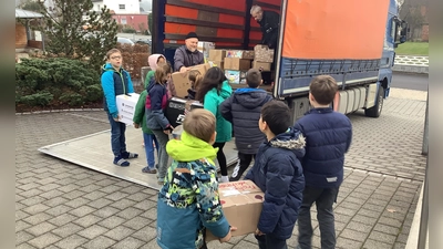 Stolz laden die Kinder ihre Päckchen in den Johanniter-Weihnachtstrucker  (Bild: Ramona Ippisch)