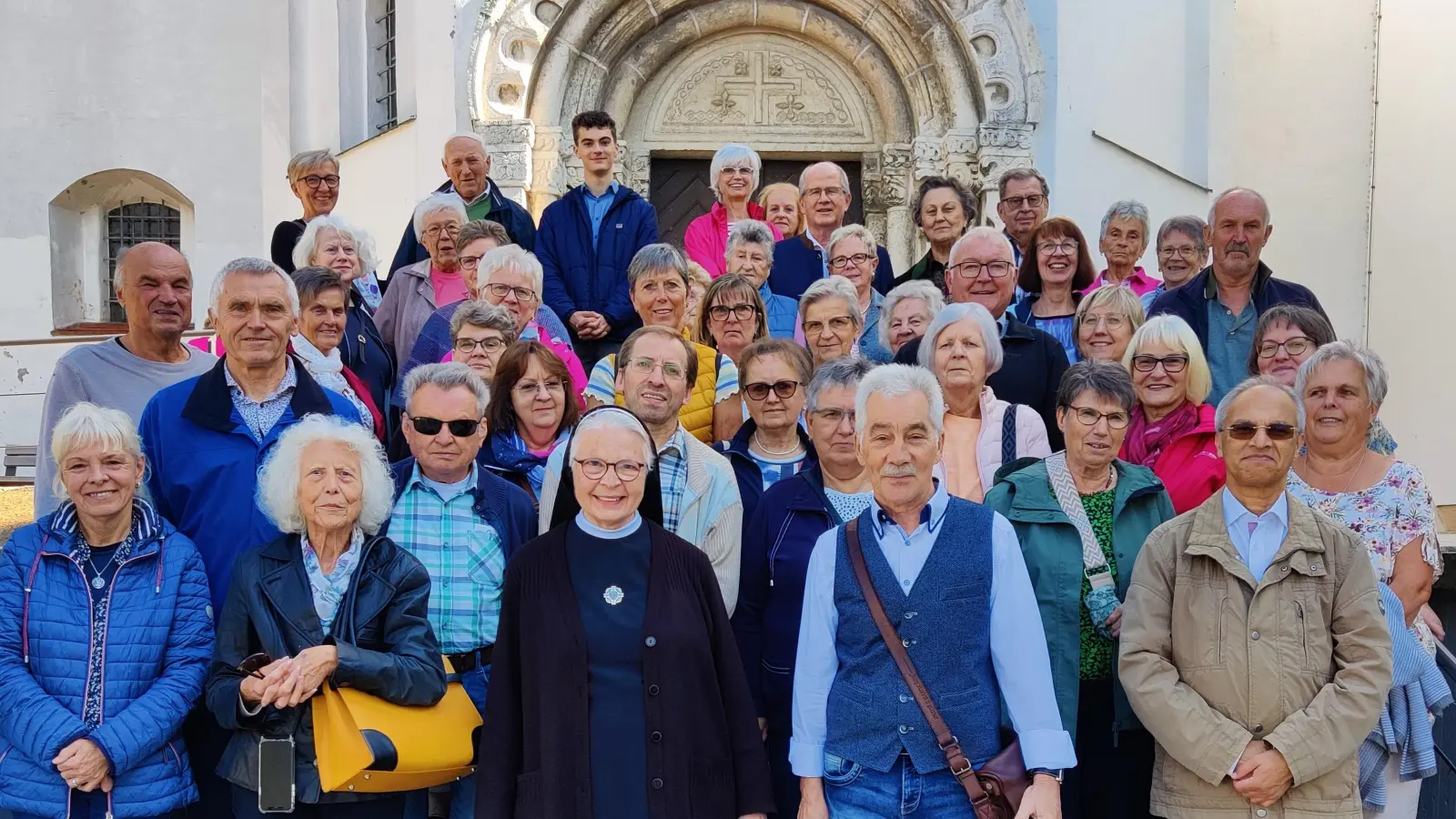 Die Teilnehmer des Pfarrausflugs mit Schwester Manuela vor dem Portal der Klosterkirche St. Johannes in Mallersdorf  (Bild: Thomas Rauch)