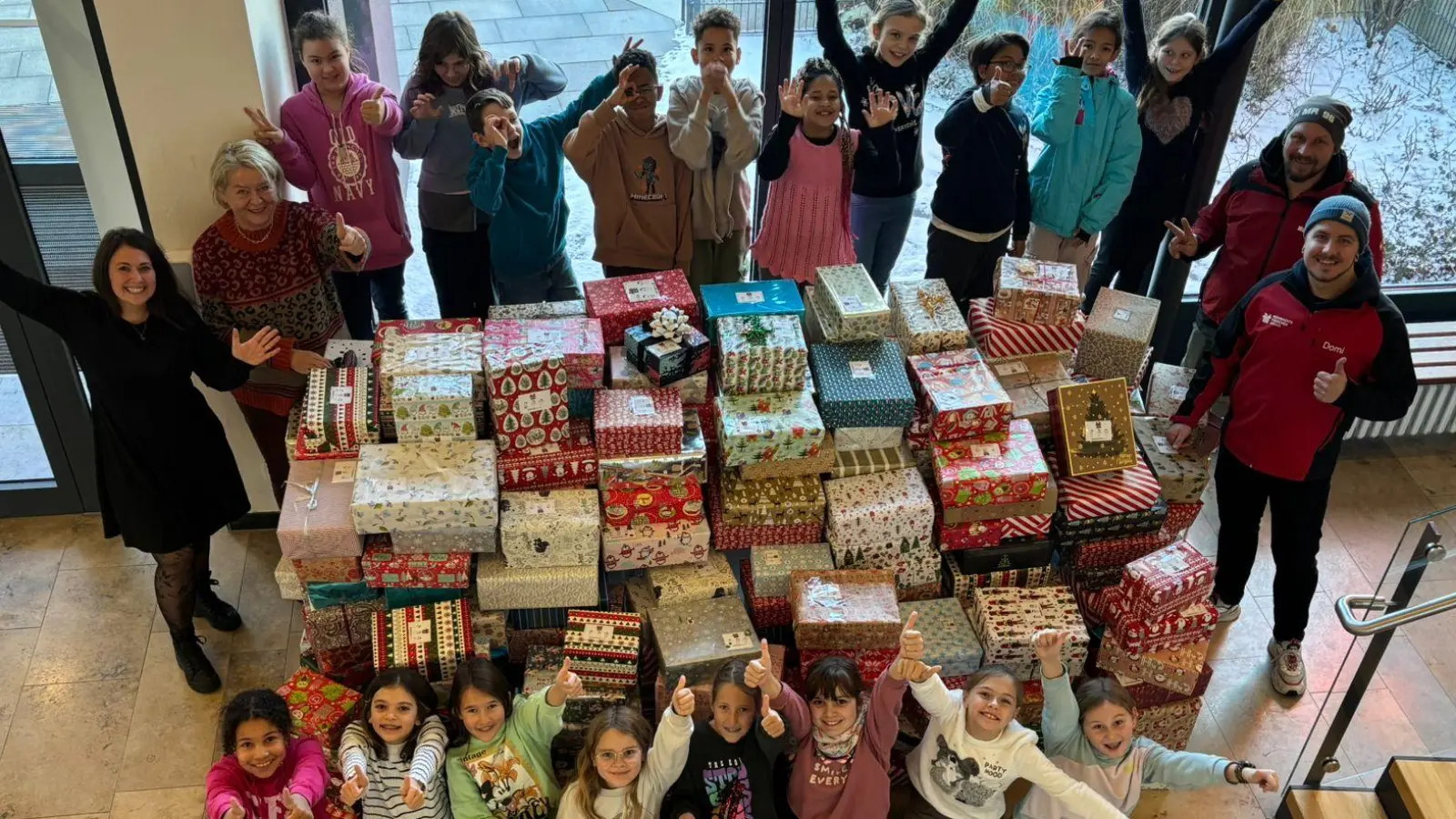 Mit überschwänglicher Freude übergibt die Klasse 4b stellvertretend für alle Schüler der Grund- und Mittelschule Vilseck die 235 Weihnachtspäckchen zusammen mit der Organisatorin Selina Apfel und Rektorin Petra Ligensa (links) an die beiden Vertreter von Round Table 235 Sulzbach-Rosenberg, Dominik Lenz und Markus Kurz (rechts). (Bild: Karl Heinz Grollmisch)