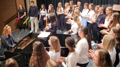 Die beiden Chöre des Luisenburg-Gymnasiums präsentieren beim Sommerkonzert „Dance Monkey“ von Tony Watson zusammen mit Chorleiterin Anna Schmitt am Klavier.  (Bild: Markus Wagner/exb)