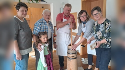 Von links: zweite KAB-Vorsitzende Melanie Bauer, kleine Zuschauerin und Zuschauer Armin Kellner, zweiter KAB-Vorsitzender Lothar Rauch, Vorsitzende Christine Pscherer und Simone Glaser vom engagierten Team. <br>Auch die Mehlmeiseler Kirwaburschen und -moidla besuchten traditionsgemäß das „Ausbuttern“.  (Bild: Gisela Kuhbandner)