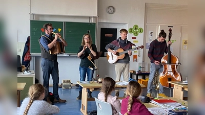 Stellvertretender Bezirksheimatpfleger Florian Schwemin war mit Lucia Wagner, Sebastian Gröller und Matthias Wolf in die Grundschule gekommen, um das Kinderliedprojekt des Bezirks vorzustellen (Bild: Grundschule Krummennaab/exb)