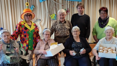 Eine Überraschung in Form von Krapfen gab es für Senioren im Heim St. Martin. Mit im Bild (stehend, von links) Gerontofachkraft Kathrin Dietz, Norbert Fleißner, Heimleiter Bernhard Riedl und Monika Grötsch von „Leben plus“. (Bild: Kathrin Dietz/exb)