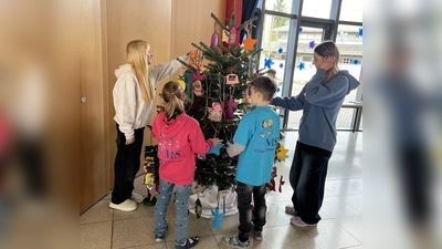 Schülerinnen und Schüler behängen den Wuschbaum in der Aula der Schule. (Bild: Michaela Bergmann)