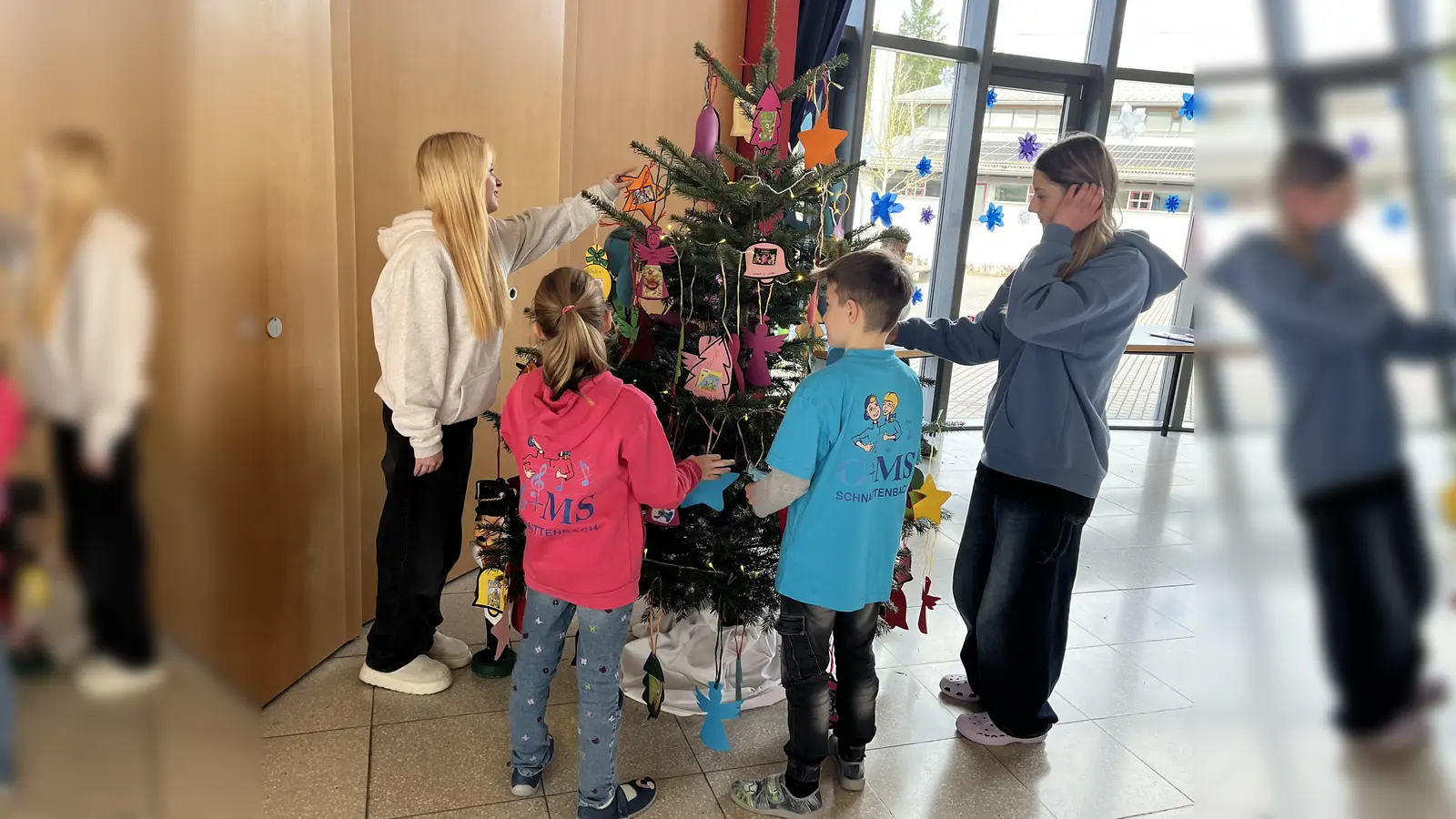 Schülerinnen und Schüler behängen den Wuschbaum in der Aula der Schule. (Bild: Michaela Bergmann)