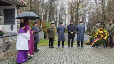 Bürgermeister Schauer, Mitglieder der SRK, der Feuerwehr und der Bundeswehr versammeln sich am Thansteiner Kriegerdenkmal, um mit Pfarrvikar Emmanuel Ogbu der Kriegsopfer zu gedenken. <br><br> (Bild: dl)