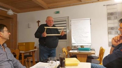 Reinhold Ziegler (stehend) riet den Zuhörern, sich bei allen Bienenvölkern auf ein Maß bei Waben und Beuten festzulegen. (Bild: Imkerverein Kemnath/exb)