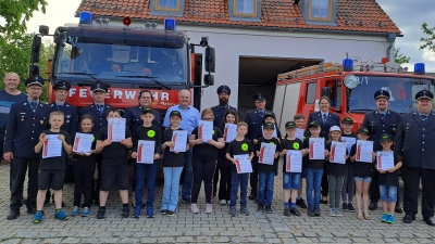 Die 17 Kinder, die alle die Prüfung zur Kinderflamme geschafft haben, bekamen Urkunden. Auch die Ausbilderinnen und Ausbilder sowie Feuerwehrleute und der Bürgermeister gratulierten. (Bild: Christina Schwendner/exb)