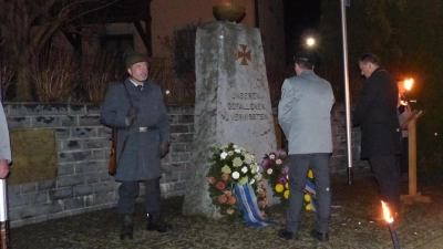 Bürgermeister Anton Kappl und der Vorsitzende der Soldaten- und Reservistenkameradschaft Döllnitz, Bernhard Kammerer, legen am Mahnmal in Döllnitz Kränze zur Erinnerung nieder. (Bild: sl)