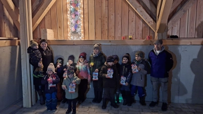 Das vierte und damit letzte Adventsfenster eröffnet die Bastelgruppe Thanstein (links Organisator Christina Mühlbauer). SRK-Vorsitzender Ulrich Knoch (rechts) übergab den Kindern ein kleines Weihnachtsgeschenk. (Bild: mnt)