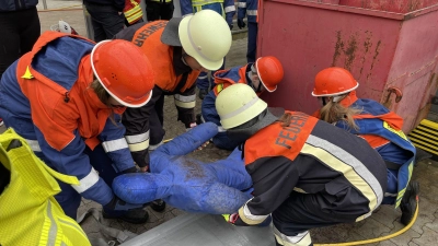 Die Nachwuchskräfte der Jugendfeuerwehren NeustadtWN und Störnstein befreien eine eingeklemmte Person unter einem Container – eine von vielen Einsatzübungen unter Realbedingungen beim Berufsfeuerwehrtag 2024. (Bild: Corinna Hagn/exb)