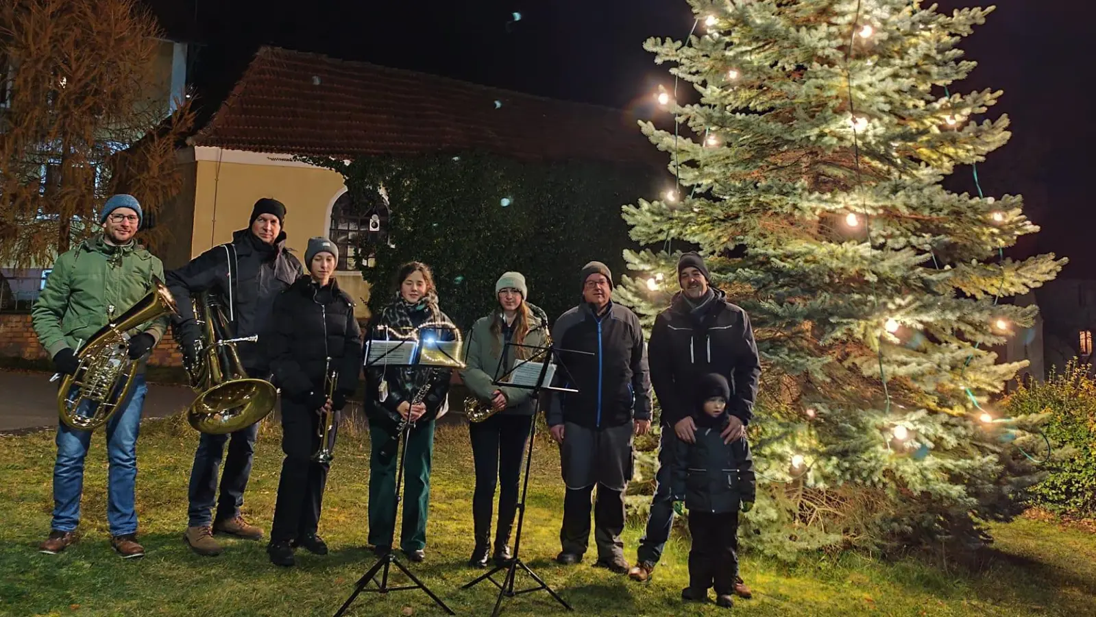 In Adlholz wird die Adventszeit eingeläutet, erstmals erstrahlt der Dorfchristbaum. Darüber freuten sich, von links: Michael Luber, Christian Winklmann, Jasmin Winklmann, Anna-Lena Graf, Nadine Winklmann, Markus Rauscher, Matthias und Jonas Köstler.  (Bild: Markus Rauscher)