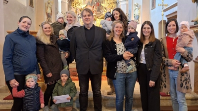 Die Mütter der Krabbelgruppe mit ihren Kindern bei der Spendenübergabe. (2. v. links Leiterin u. Organisatorin des Kuchenpaketeverkaufs Melissa Weiß, Mitte Pfarrer O. P. Pollinger) (Bild: Daniela Malzer)