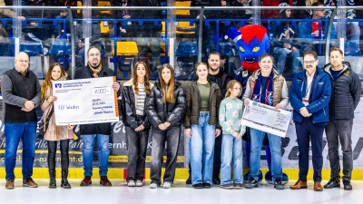 Spendenübergabe beim Spiel der Blue Devils gegen Rosenheim: Die Schulleitungen der Pestalozzi-Mittelschule (3.v.l.) und der Lobkowitz-Realschule (3.v.r.) überreichen zusammen mit Lehrkräften und Schülersprecherinnen die Spendenschecks. (Bild: Tobias Neubert)