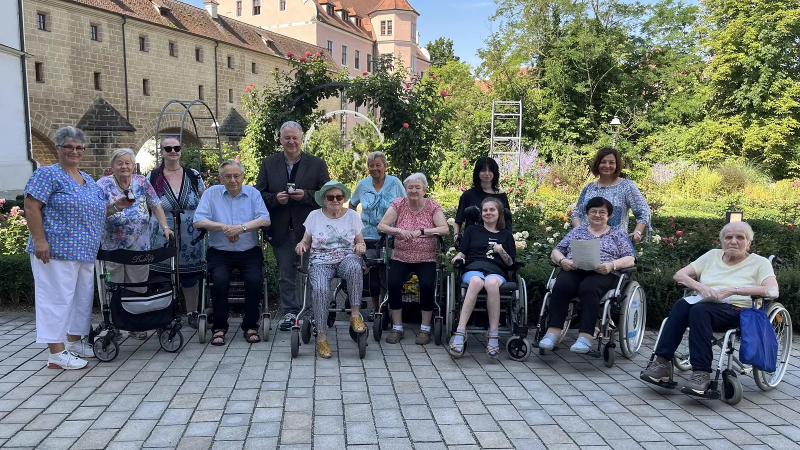 Im Rosengarten überreichten Marion Freibott (ganz links) und die Bewohner des Marienheims das selbstgemachte Rosengelee an Landrat Richard Reisinger. (Bild: Christine Hollederer)