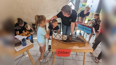 Unter Anleitung durften die Mädchen und Buben Zither, Gitarre, Akkordeon und Hackbrett selber ausprobieren. (Bild: Heidi Banzer)