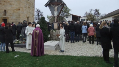 Ruhestandsseelsorger Josef Beer mit den Ministranten am Pittersberger Priestergrab beim Gebet für die Verstorbenen an Allerheiligen, dahinter zahlreich die Gläubigen an den Gräbern.  (Bild: Michael Götz)