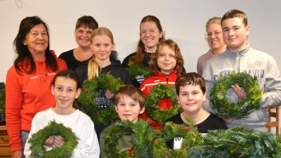 Stolz zeigen die Mitglieder der Kindergruppe „Natur Pur” ihre Adventskränze. Unterstützt wurden sie von (li.stehend) Irmi Dolles, Tanja Schumann und (hinten re.) Sabine Siegler. (Bild: Fritz Dietl)