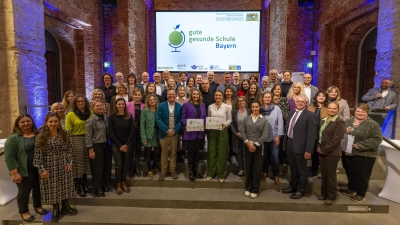 Auszeichnungsveranstaltung „Gute gesunde Schule”<br>mit Anna Stolz (Mitte l.), bayerische Staatsministerin für Unterricht und Kultus und Judith Gerlach (Mitte r.), bayerische Staatsministerin für Gesundheit, Pflege und Prävention, Stefanie Lutye-Küst (6. v. li. hinten). (Bild: Michael Balk)