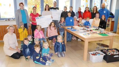 Sonja Winter, Melli Roppert, Anja Roppert, Luisa Hebauer von der Basarleitung, Sonja Winter Kindergartenleitung, Manu Endres Schulleitung, Elisabeth Dehling und Inge Behringer Kinderturnen, Manfred Pirner und Nico Hebauer FC Edelsfeld und einige Kindern aus der Schule und dem Kindergarten vor dem neuen Lego-Kreativ-Tisch in der Schulaula. (Bild: Rudi Gruber)