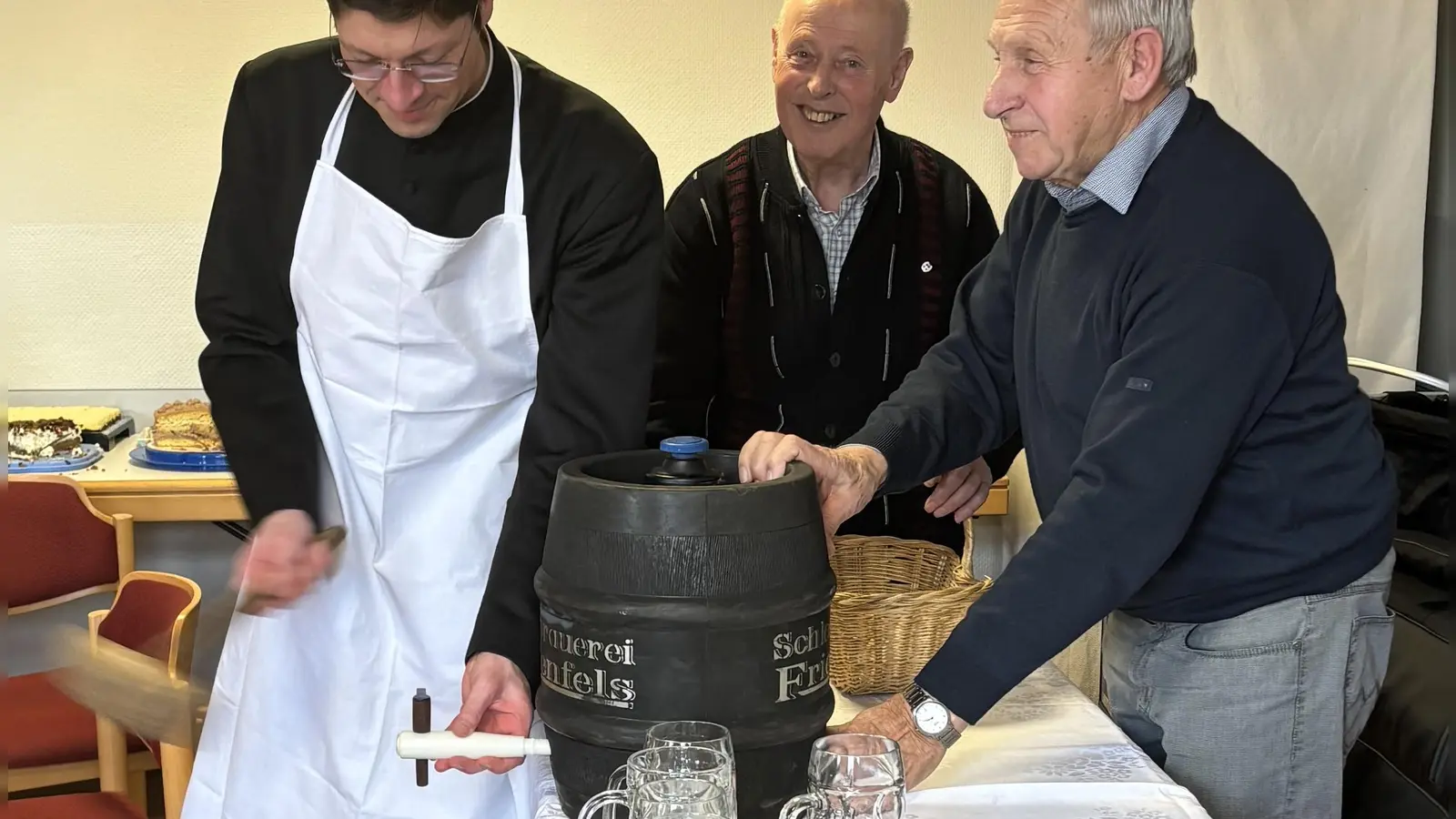 Gekonnt wurde das Fass von Pfarrer Gierl (links) mit drei Schlägen angezapft. Vorsitzender Franz Völkl (Zweiter von links) und Ernst Luk (rechts) beobachten das Geschehen.  (Bild: cro)