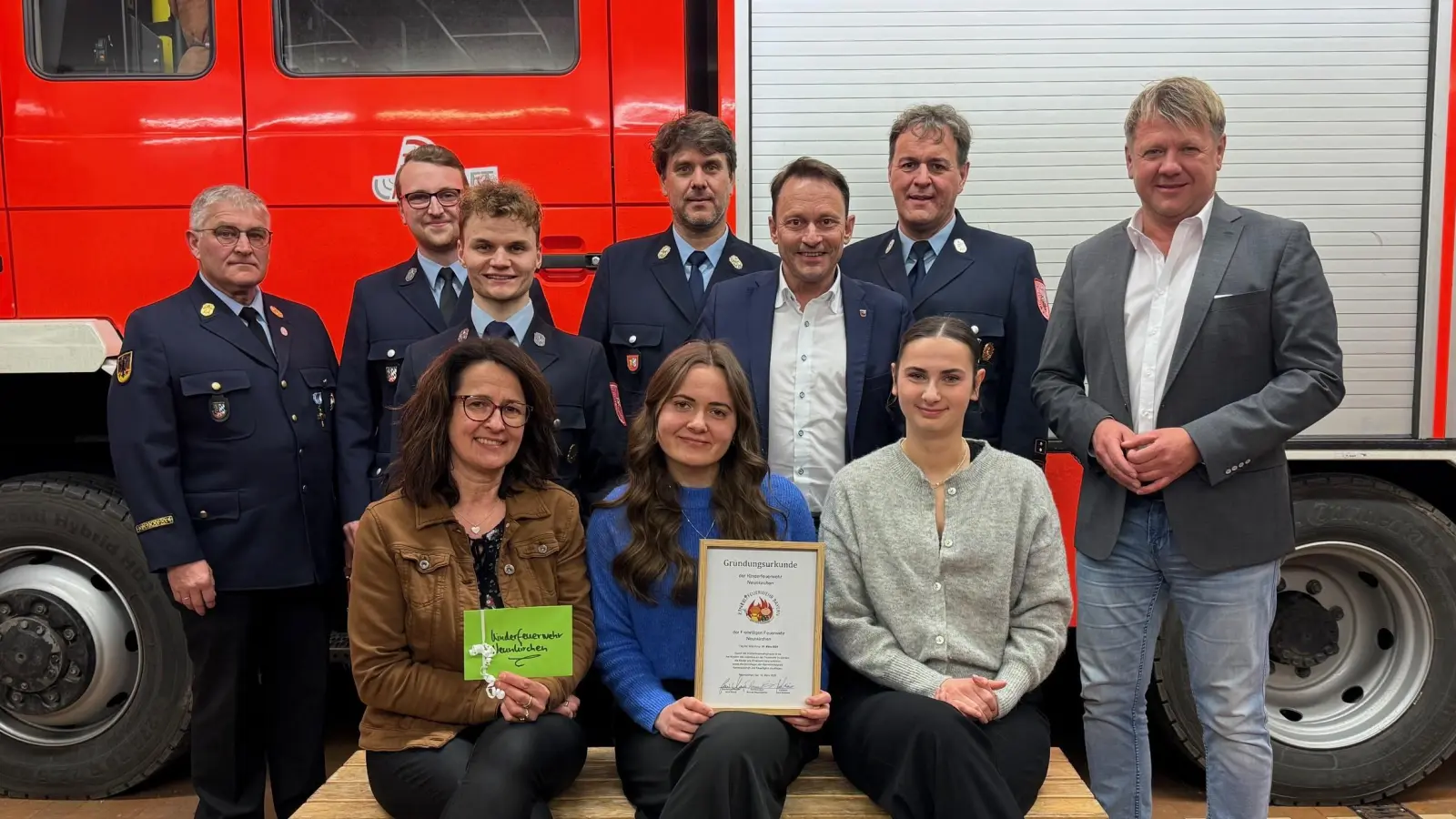 Die Feuerwehr Neunkirchen gründet eine Kinderfeuerwehr. Betreut wird sie von (vorne, von links) Regina Miederer, Luisa Miederer und Luisa Steinsdörfer. Die Vertreter der Stadtpolitik mit Jürgen Meyer (rechts) und OB Jens Meyer (Vierter von rechts) sowie die der Stadtfeuerwehr freuen sich über die Initiative. (Bild: Laurenz Miederer)