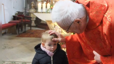 Ruhestandspfarrer Josef Beer segnet die kleine Klara in der Pittersberger Nikolauskirche und macht ihr das Kreuzzeichen auf die Stirn.  (Bild: gm)