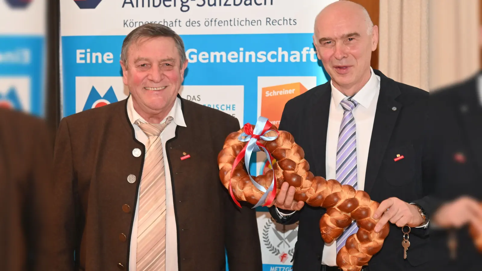 Einen übergroßen Brezenschlüssel übereichte der bisherige Kreishandwerksmeister Johann Weber (links) seinem Amtsnachfolger Dietmar Lenk (rechts), damit dieser künftig immer, wie Weber sagte, „Zugang zu seinem Büro bei der Kreishandwerkerschaft hat”.<br> (Bild: gf)