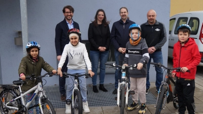 Konrektor Peter Grosser (links) und Elternbeiratsvorsitzender Alexander Ried freuen sich über die Spende von drei Kinderrädern von Janine und Christian Feierfeil. (Bild: Elfriede Weiß)